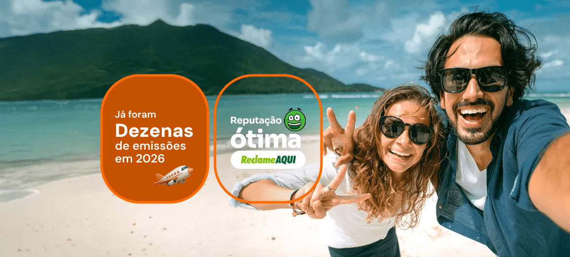 Casal sorrindo em uma praia tropical, com selo de dezenas de emissões em 2026